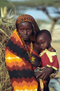Young Gabbra mother and child at Kalacha (Chalbi desert). The Gabbra live in the Chalbi desert of northern Kenya, between Lake Turkana and Moyale and Marsabit, extending into the Bula Dera plain east of the Moyale-Marsabit road, and the Mega escarpment in southern Ethiopia. hey share portions of this area with the Borana, Rendille, Samburu, Daasanech and Turkana. They still roam with their herds across the border. The Gabbra are an Eastern Cushite people related to the Somali-Rendille in t...