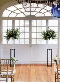 Leaf + Petal NOLA created tall lush altar arrangements and simple aisle markers of neutral garden florals and greenery for a New Orleans garden wedding at Marche.