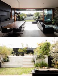 Large full height sliding glass doors open this modern interior to the backyard that has a raised outdoor dining area. #Doors #Landscaping#Backyard #SlidingGlassDoors