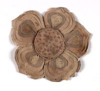 Flower made of paper painted with ink and colours, cut and pasted together.