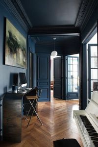 intérieur classique sol en parquet naturel, plafond et mur bleu foncé, piano décoratif couleur blanc