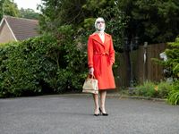 Senior women with plaster on face holding handbag
