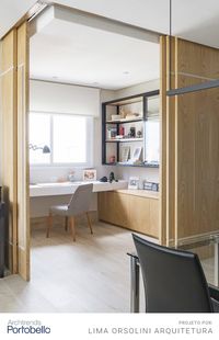 Uma home office funcional e aconchegante integrado à sala de jantar e de estar, com direito a muita luz natural. Para momentos de privacidade, foram inseridas portas de correr de madeira clara, que deram um toque de modernidade ao ambiente. A cor eleita para predominar o espaço foi o cinza, que combinou perfeitamente com o piso de madeira em porcelanato, e tons de azul e preto nos móveis e objetos decorativos.