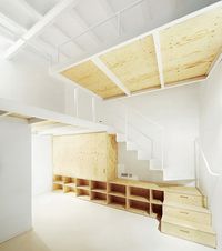 A renovated apartment in the El Born area of Barcelona featuring wooden storage and mezzanines.