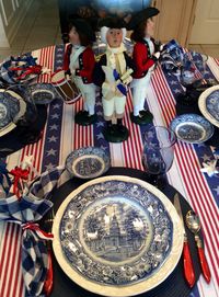 Stars & Stripes table features Liberty Blue vintage dishes. Centerpiece is trio of Byer's Choice figures - George Washington with fife and drummer.