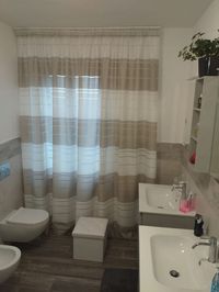 Tenda classica, installata su binario a 2 vie, in tessuto viscosa per bagno