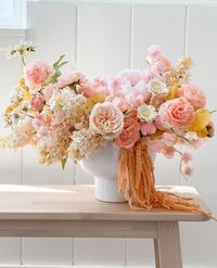 Skip the florist and create your own, stunning summer wedding floral centerpiece. Start with a chicken wire ball for your base and stick in the bottom of a compote bowl. Add in your larger faux flowers and fill in with smaller blooms as you go. Shop for everything you need to create your own wedding centerpieces at Afloral.com.