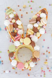 A super cute EASTER BUNNY CAKE HACK made from store-bought unfilled sponge cakes, frosting, macarons, Easter eggs, mini meringues & more! #easter #bunny #cake #hack #woolies #coles #wooltworths #sponge #creamtart #easterbaking #macarons #recipe