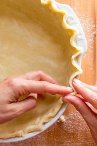 This homemade pie crust recipe yields a flaky tender crust with rich buttery flavor. It has simple, natural ingredients and uses only butter (NO SHORTENING). Learn how to roll and transfer pie dough, form a fluted pie rim, "blind bake" or pre-bake pie crust and discover surprisingly simple alternatives for pie weights. | natashaskitchen.com