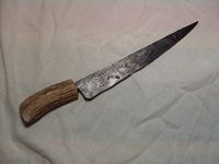 An early medieval knife. Suitably rustic with a forged iron blade. Both wooden handled and antler handled items are available. This is a sharp, practical item which can be used for a range of domestic tasks. Suitable for the early medieval period from about 900ad until the fourteenth century.
