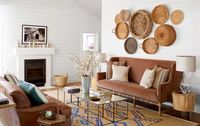 New sofas, coffee tables, and lamps effortlessly coincide with one-of-a-kind finds. The asymmetric configuration of collected baskets brings texture and tonal hues that feel at home among the contemporary pieces in this living room.