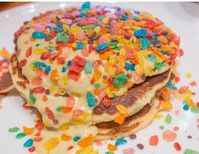 Happy Mardi Gras! It's Fat Tuesday and to celebrate, we're serving up a colorful breakfast! These Mardi Gras pancakes are nothing but delicious fun with colorful fruit flavored rice cereal mixed into our favorite Krusteaz pancake mix. To top them off, a sweet crème anglaise ties it all in with some additional fruit flavored rice cereal for extra crunch and color. #krusteaz #pancakes