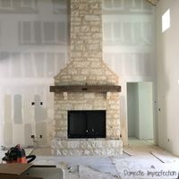 large woodburning fireplace covered in rustic stone