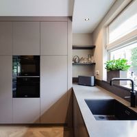 Noem het beige, greige, grijs of taupe, mooi is hij zeker! Deze strakke greeploze keuken.