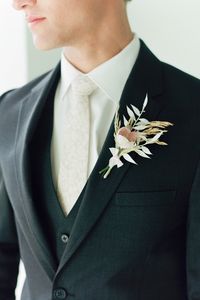 Create a simple ruscus boutonniere with affordable dried flowers and grasses from Afloral.com. Image by @ruffledblog #groom #weddingboutonniere #diywedding