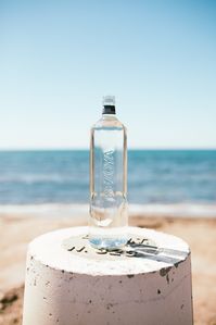 Botella de vidrio de agua mineral Bezoya. Foto realizada en una playa de Águilas, Murcia.