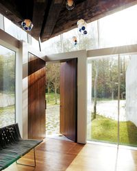 While most homes have their front doors centered on a flat wall, this home in Canada by Omer Arbel is entered through two solid walnut doors at the corner of the home. #door