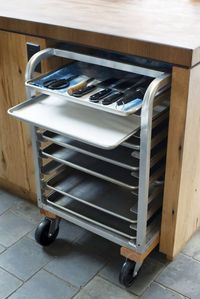 A commercial rolling cart tucks into the kitchen island. The crew at Scribe use the cart for storing cooking utensils, parchment, and flatbread.