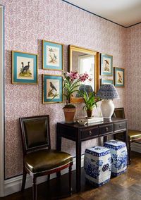 foyer, red floral wallpaper, wooden side table, plants