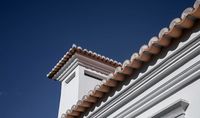 Architecture & Interior Design Photography | Helena Amante | Traditional Portuguese architecture of red-tiled rooftop and chimney against a deep blue sky. Luxury villa in Sintra, Portugal, by Estoril & Cascais Atelier Antonio Nunes da Silva.