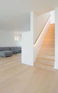 Ooms Woonrealisaties | eiken trap met treden in verstek | muurleun in inox met ingewerkte LED verlichting