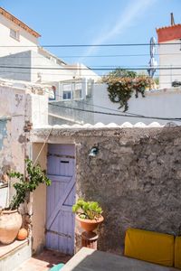 Mur en pierres et porte de jardin violette à l'adresse Jogging Samena à Marseille - The Socialite Family #joggingsamena #outdoor #extérieur #terrasse #jardin #samena #marseille #pierre #mur