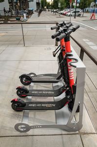 Dismount XL electric and push scooter parking racks efficiently increases sidewalk safety. Scooters are cradled in place by the patented wheel chock, edge protected slots allow for lockability with short cable, chain or U-locks