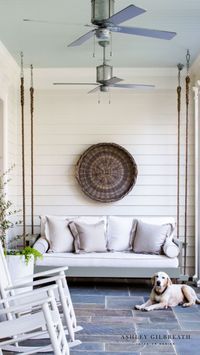 ASHLEY GILBREATH INTERIOR DESIGN: “IT HAS A KICK-BACK-AND- RELAX FEEL TO IT, BUT STILL IS VERY SOPHISTICATED.” ARCHITECT BRANDON INGRAM. A custom, handmade bed swing is the perfect addition to a traditional southern porch with it's classic white rocking chairs overlooking the lake.