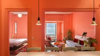 High chroma colour scheme featuring orange/pink that contrasts beautifully with the azure blue sea in Waterfront Nikis apartment, Thessaloniki, designed by architect Stamatios Giannikis. In the apartment, azure blue is used to reflect the Mediterranean Sea and flamingo orange/pink is used as a contrast to enhance the colour of the Sea. Pastel green is used in the kitchen. Image credit: Dezeen.