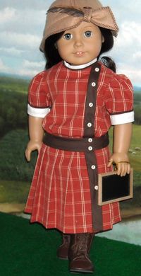 1914 Burnt Sienna Check Frock for 18 inch by SugarloafDollClothes. A dress for Rebecca in a lovely, deep homespun check with contrast white fabric on the high collar and on the sleeve cuffs, both further decorated with brown soutache braid. Tiny ivory buttons march down the bias cut front brown band. A little slate for school is included.
