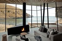 Inside, the home is really just one room with a bed, a fireplace and sitting area, and a small kitchen. Photograph by Simon Devitt.