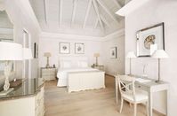 Gabled ceilings, exposed beams and light hardwood floors lend character to a white bedroom. If you’re looking to add a hint of glimmer, silver candelabras and frames will do the trick. Image courtesy, Cheval Blanc St-Barth Isle de France
