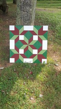 A two foot by two foot barn quilt done with maroon, hunter green and defining white that makes the whole board come alive. It has been sealed properly to protect the paint and wood both from weather and erosion.