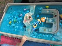 "diving at sea shell cove" real sea shells, water, blue and green food coloring, orange and strawberry extract, plastic fish, a dolphin toy, glass gems, river rocks, and a little plastic boat... oh and action figures to go diving!
