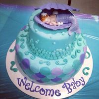 Gorgeous sea-themed baby shower cake with a baby mermaid to top it off.