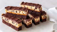 When you want a truly rich dessert, you have to go straight to the top. No more millionaires and billionaires; that's just not rich enough for your tastebuds. No, you have got to have Trillionaire Bars! Trillionaire Bars layer fudgy brownie, salty, buttery caramel, melt-in-your-mouth and safe-to-eat cookie dough, and a smooth, luscious, chocolate ganache one on top of the other; it's all of the best sweet treats you desire all at once. This dessert needs a monocle and a top hat, it's so decadent