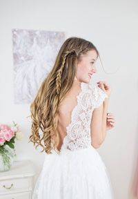 Ein tiefer Rückenausschnitt, transparente Spitze im Oberteil und verspielte Flügelärmchen machen das Oberteil von Antonia zu etwas ganz Besonderem. Der federleichte Rock, aus einer Kombination von Chiffon und Tüll verleiht dem Kleid einen Hauch von Vintagezauber. Die klassische A-Linie eignet sich perfekt für deine Sommerhochzeit und kann - so wie all unsere Designs - auch nach deinen Wünschen mitgestaltet werden.