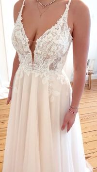 Ein Brautkleid zum Verlieben ... Leni zeichnet sich durch eine zeitlos romantische Spitze aus, die das transparente Oberteil & die Ärmelchen ziert und fließend in den märchenhaften Rock verläuft, der das elegante Design komplettiert. Die klassische A-Linie ist zu jeder Jahreszeit ein absoluter Hingucker. All unsere Brautkleider - auch Leni - kannst du in deiner Anprobe bei uns individuell mitgestalten und miteinander kombinieren, so dass du dein ganz persönliches Traumkleid finden kannst.