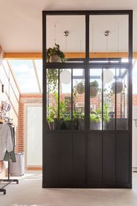 Optimisation de l’espace et aménagement malin avec cette buanderie installée dans le garage : compacte, elle regroupe lave-linge, sèche-linge, produits et rangements, dans un îlot réalisé avec des cloisons atelier.
