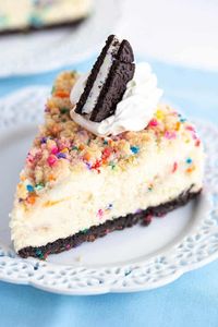 Birthday Cheesecake - This birthday cheesecake is packed full of flavor! It has a birthday cake Oreo cookie crust, a cheesecake batter with a cake batter extract and bits of sugar cookie dough in it. The top has a golden brown sugar cookie crumble. It makes a beautiful sprinkle wrapped birthday cake cheesecake for any cheesecake lover. #cookiedoughandovenmitt #cheesecakerecipes #cheesecake #birthdaycake #sugarcookies #dessertrecipes