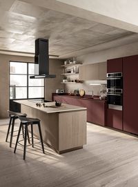Jaipur Red Fenix NTM® laminate - an extremely high-end matt material - distinguishes the 12 mm-thick worktop, the washing area with built-in sink basins and the doors of the wall-mounted composition to create an elemental, modern and highly functional style. The worktop on the island and cooking area is on the other hand in Coral Clay Quarz (20 mm thick), blending in seamlessly with the colours of this room.