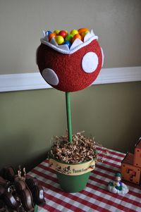 cut a triangle into a styrofoam ball, paint it and added felt spots and teeth. Covered the rim with a rope for the lips. Then painted a tera cotta pot and wooden rod found at the craft store or walmart. Weighed it down with rocks to hold it down from tipping covered it in paper crinkles and filled with gum ball eggs or m Hope this helps. Have fun and good luck with your party : )