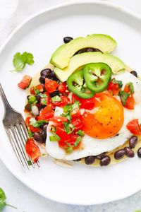 Huevos Rancheros - Lightly crisped tortillas topped with seasoned black beans, pico de gallo, avocado, and eggs. These yummy ranch-style eggs are a treat any time of day! (Gluten Free, Dairy Free) // Ranch Style Eggs // Tex-Mex Breakfast // Southwest Eggs // #texmex #huevosrancheros #eggs #brunch #glutenfree
