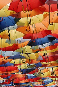 sky of umbrellas gives color to the narrow streets of the historical center of Agueda, Portugal