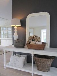 Side table, spiegel en een grijze kleur op de muur.