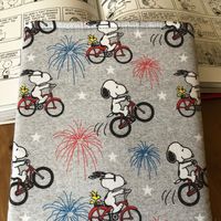 Snoopy Riding a Bicycle on Grey Padded Book Sleeve, Gift for Book Lover