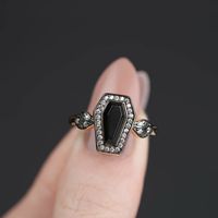 Deep black Onyx coffin shaped gemstone set within a frame of cubic zirconia. Ornate shoulders sparkle with Cubic Zirconia crystals. The perfect edgy addition for any jewellery lover's collection Choose from Sterling Silver or 18k Gold Sterling Silver This item will arrive in a branded Regalrose ring box, making a lovely gift for someone special. British brand Regalrose, design, create and hand finish their unique pieces in their London based studio. Silver or Gold Sterling Silver or 18K gold pla