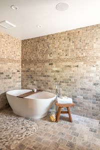 This master bath retreat uses Natural stone to surround in luxury with a freestanding tub perfect for those at home spa days #bath #masterbath #bathroominspo #bathroominspiration #naturalstone #wetroom #wetroominspiration