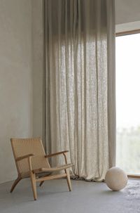In this corner, the curtains contribute with a soft light since only some of the sunlight can pass through. The armchair is Danish design by Wegner.