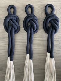"A unique wrapped and knotted wall hanging Set 3 These unique pieces are created from 100% cotton, these pieces are a perfect addition to your living room, bedroom, office or entry way. It's three dimensional and made from quality rope and yarn. Each knott has 20 strands of 5mm twisted cotton string. Measures : 7 \" W x 50\" L. Each Color: Black If you're looking for more fiber art inspirations, you can find me on my Instagram: @mg.interiordesign"